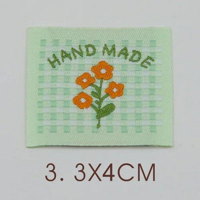 Ar rokām darināta auduma etiķete noliktavā, jauks pleds mazs zieds, kaķu izšuvumi, austa etiķete, aksesuāri, šūšana, krāsaina etiķete