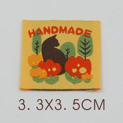 Ar rokām darināta auduma etiķete noliktavā, jauks pleds mazs zieds, kaķu izšuvumi, austa etiķete, aksesuāri, šūšana, krāsaina etiķete