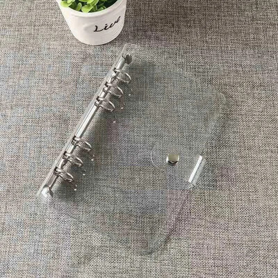 Caurspīdīga PVC mape, grāmatu vāks, atsperu iesiešana ar vaļējām lapām A6 izmērā