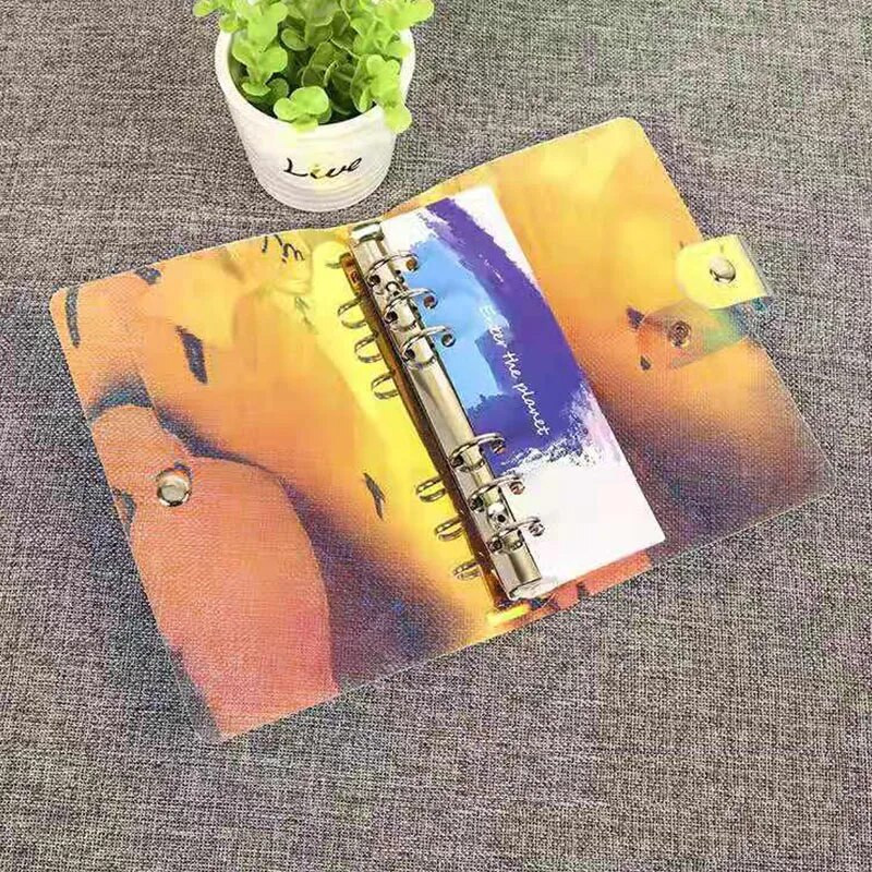 Caurspīdīga PVC mape, grāmatu vāks, atsperu iesiešana ar vaļējām lapām A6 izmērā